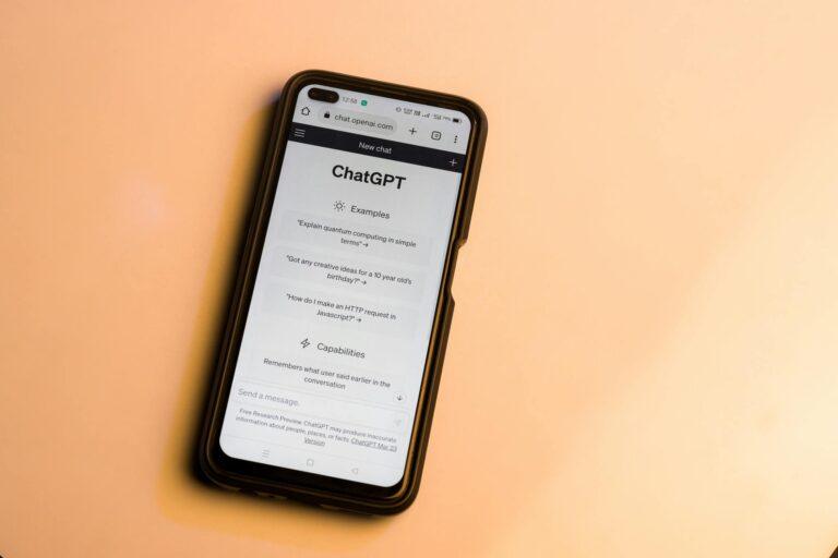 Smartphone showing ChatGPT website with warm tone, highlighting AI technology.