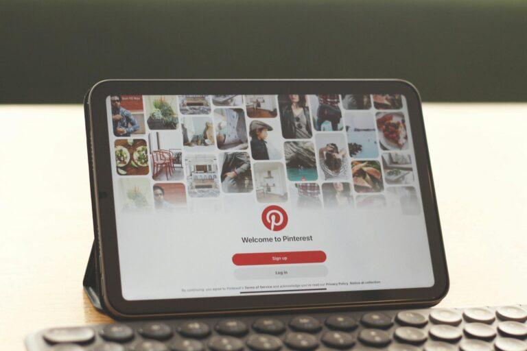 Tablet showing Pinterest homepage on a modern desk setup with a keyboard.